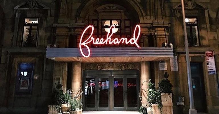 A neon sign is lit up on the front of a building.