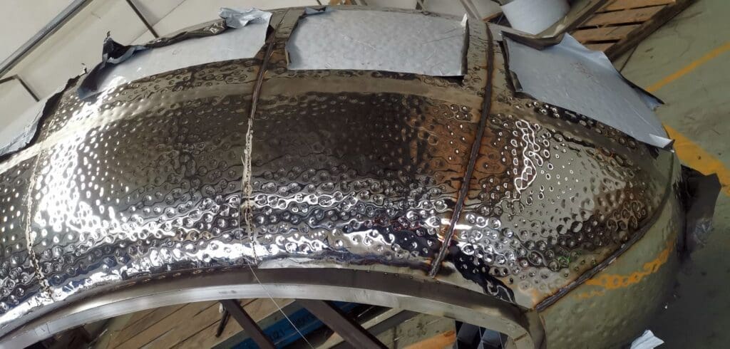 A metal sheet is being made to look like a car.