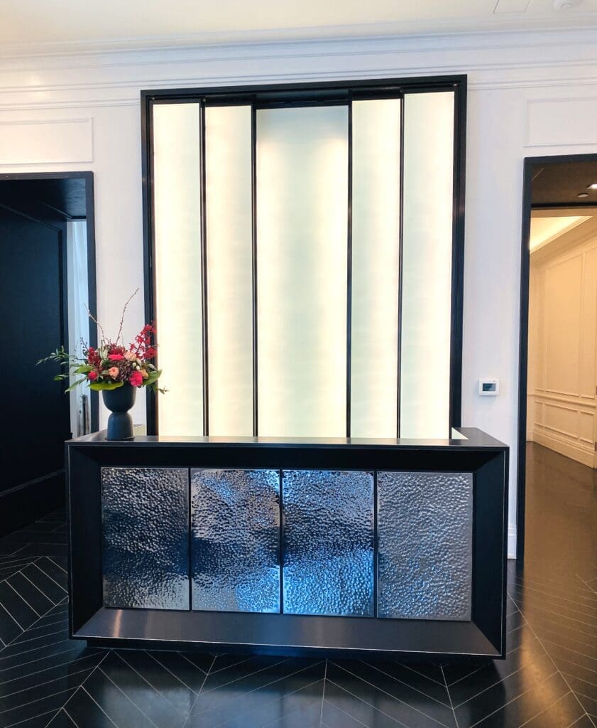 A room with a large glass wall and a black table