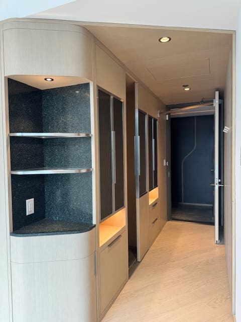 Modern hallway with built-in shelves and lighting.