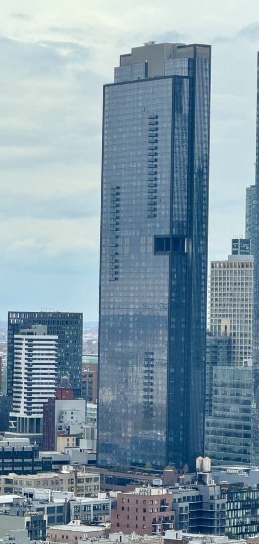 Tall modern skyscraper against cloudy sky background.