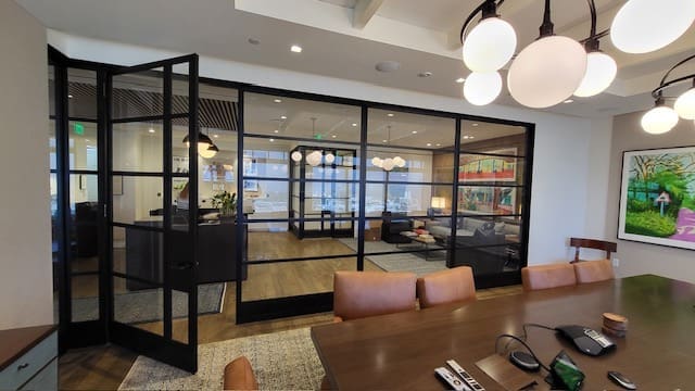 A room with glass walls and wooden table.